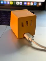 Foto real do Mupli visto por trás, com as saídas de ventilação e o cabo USB-C conectado.
